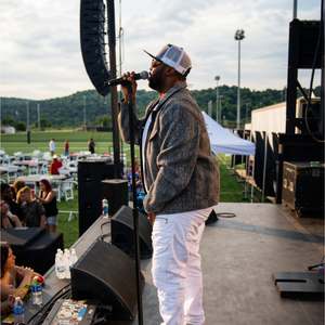 Stephen Thomas singing at the mic stand during his Woody Fest performance